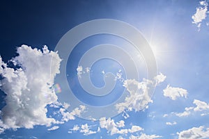 Blue sky background with white clouds and sun