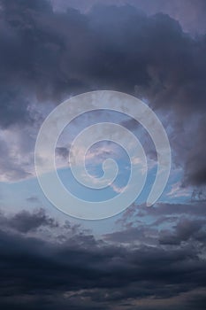 Blue sky behind dark storm clouds background texture