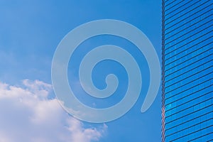 Blue sky with cloud and modern blue office building.