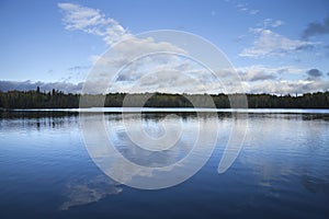 Blue sky and clouds over calm lake at dusk in northern Minnesota