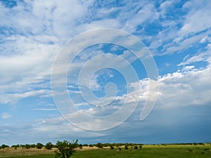 Blue sky and clouds over green fields