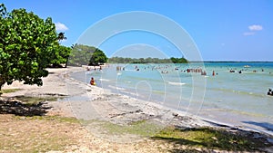 Blue sky and clouds over a tropical beach with green trees in Playa Larga, Cuba. photo