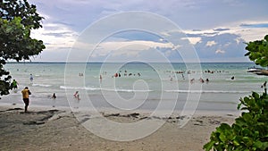 Blue sky and clouds over a tropical beach with green trees in Playa Larga, Cuba. photo