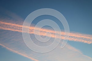 Blue sky with clouds and pink vapour trail as a background