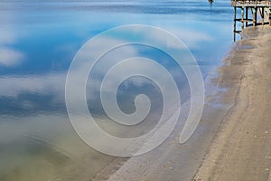 Blue sky and clouds reflected in still bay waters, Tybee Island Georgia USA