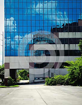 Blue Sky and Clouds Reflection in Modern Abandoned Building Exterior Facade.