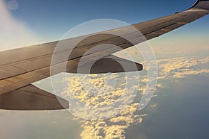 Blue sky with clouds under the wing of an airplane.