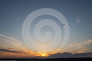 Blue sky. Color clouds. Sunset background. Plane over the horizon. Sunset sky.