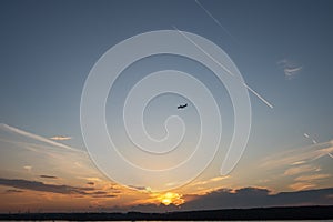 Blue sky. Color clouds. Sunset background. Plane over the horizon. Sunset sky.