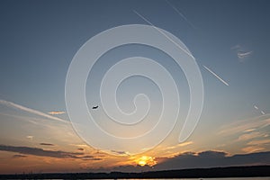 Blue sky. Color clouds. Sunset background. Plane over the horizon. Sunset sky.