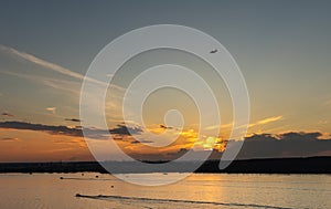 Blue sky. Color clouds. Sunset background. Plane over the horizon. Sunset sky.