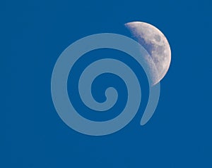 Blue sky daytime half moon