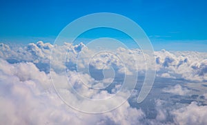 Blue sky with fluffy clouds, natural cloudscape view from plane window. Airplane travel concept. White clouds overcast