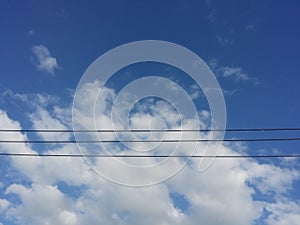 blue sky with fluffy cloudy and cable wire line