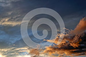 Blue sky with gold clouds - dramatic sunset, beautiful natural background. Setting sun illuminates the clouds.