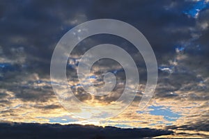 Blue sky with gold clouds - dramatic sunset, beautiful natural background. Setting sun illuminates the clouds