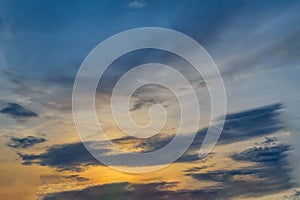 Blue sky with gold clouds - dramatic sunset, beautiful natural background. Setting sun illuminates the clouds