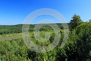 Blue sky and green valley with forest