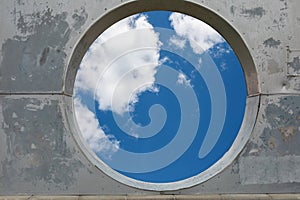 Blue sky hole in aged concrete wall background