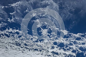 Sun rays shinning in the blue sky with layer of clouds viewed from above.