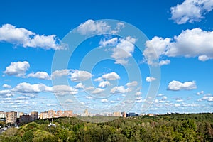 Blue sky with many white clouds over park and city