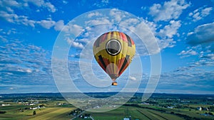 Blue sky and multiple clouds and a hot air balloon
