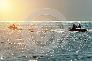 Blue sky Orange light on the sunset. silhouette of a banana boat jet ski have fun