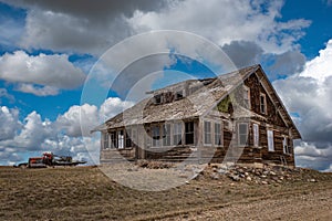 Blue sky over an abandoned home and truck on the prairies of Saskatchewan