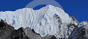 Blue sky over a high snow covered mountain in the Himalayas, view from Gorakshep