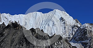 Blue sky over a high white mountain in the Himalayas, view from Gorakshep