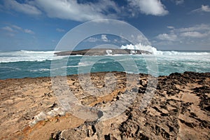 Blue sky over Laie Point rocky coastline with storm surf crashing at Kaawa on the North Shore of Oahu Hawaii USA