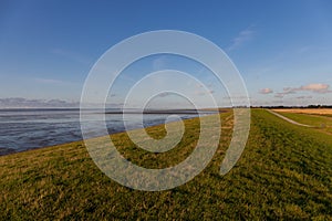 Blue sky over the sea and grassy coast in Ostfriesland Germany