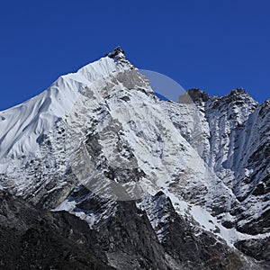 Blue sky over a snow covered peak seen from Gorakshep