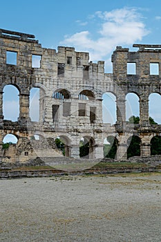 Blue sky with puffy cloud through the Pula Arena arches in Croatia