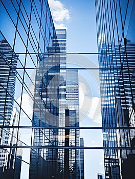 The blue sky is reflected in the mirrored surfaces of modern business buildings. Generated by AI