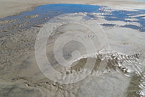 Blue sky reflected in shallow tide pools on a sandy beach, Tybee Island Georgia USA, creative copy space