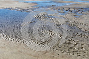 Blue sky reflected in tide pools on the beach, Tybee Island Georgia, USA