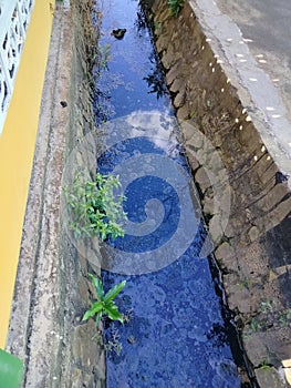 The blue sky reflecterd from the dirty drain