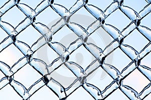Blue Sky Refracted by Ice on a Metal Chain Link Fence