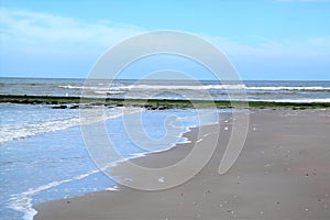 Blue sky, sea, waves and sandy coastline