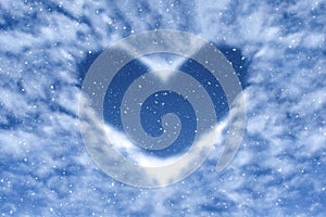 Blue sky with snow and clouds in heart shape. Happy and love background.