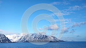 Blue sky and snow covered rugged mountains near Hamnoy on the Lofoten in winter in Norway