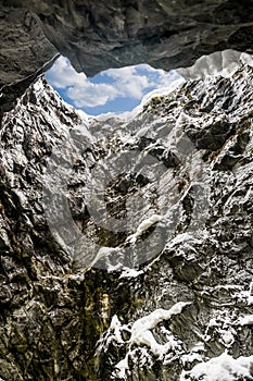 Blue sky at the top of the vertical tunnel in the mountains