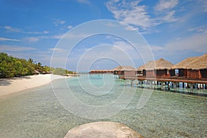Blue sky turquoise water luxury Overwater Villa connected to Beach with Platform at a resort island, Maldives