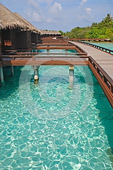 Blue sky turquoise water a perfect Holiday on Overwater Bungalow wooden platform walkway at a tropical resort island, Maldives