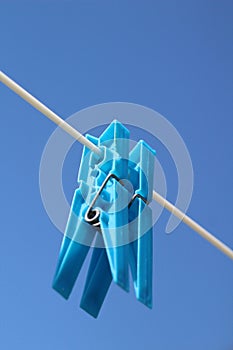 Two blue plastic cloths peg on a washing line on a hot summers day with a clear blue sky in background