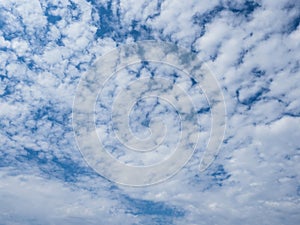 Blue sky with unusual fluffy abstract white clouds structure.