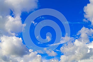 Blue sky and white clouds in a circle. Frame made of white clouds on a sunny day. Natural background.