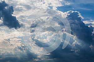 Blue sky with white clouds and curly dark rain clouds. Sky background.