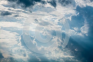 Blue sky with white clouds and curly dark rain clouds. Sky background.